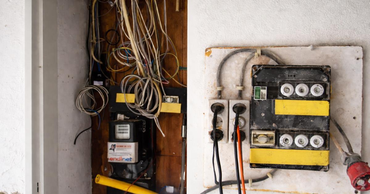 Oude stoppenkast met rommelige bedrading in woning